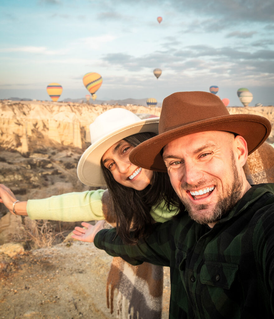 Dental Tourism Patients smiling with air balloons in the background in Cappadocia, Turkey.