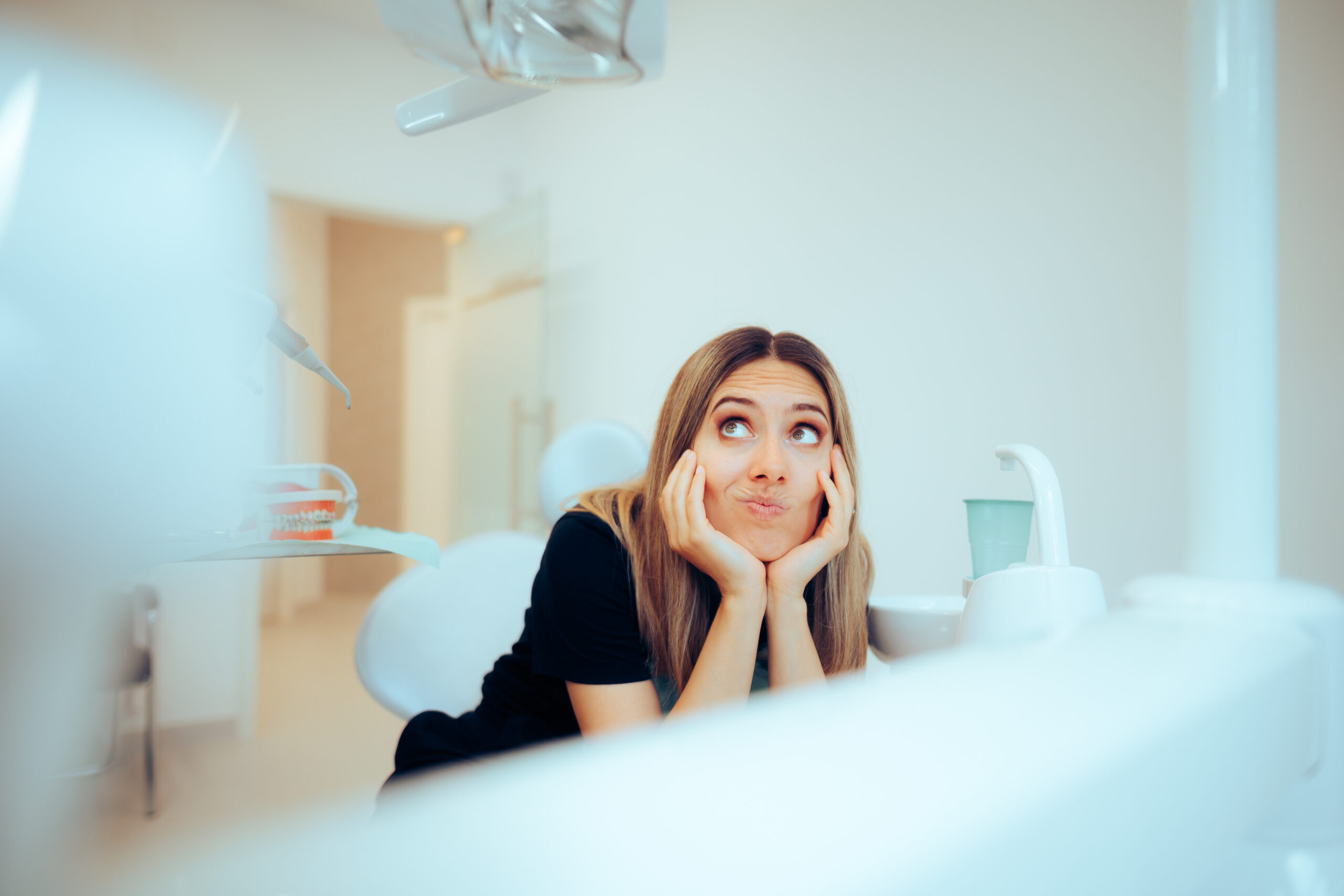 Confused patient in dental clinic contemplating dental crown options and quality care.