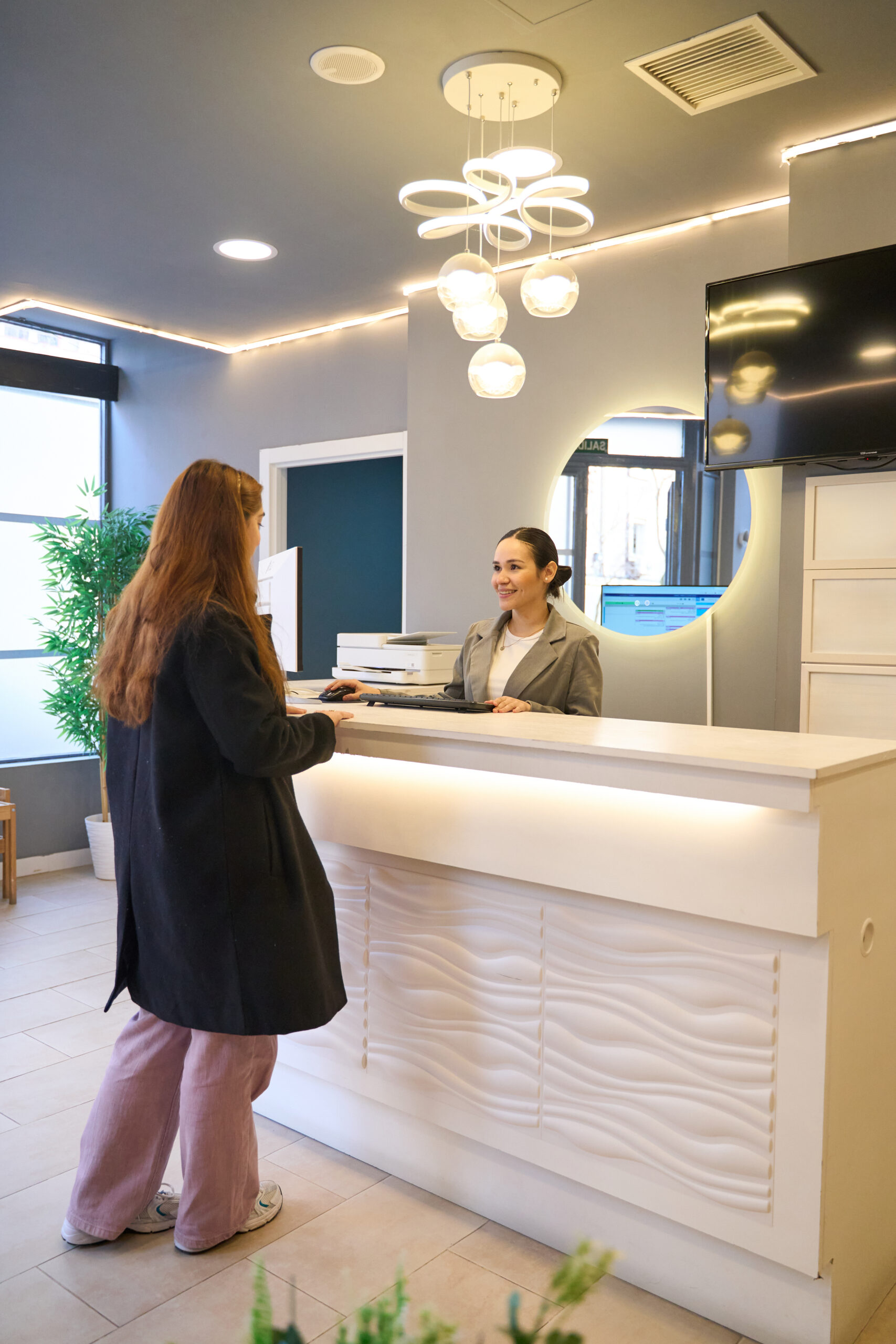 Patient interacting with reception staff at a modern dental clinic in Istanbul, highlighting a welcoming environment for international dental care seekers.