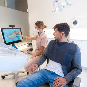 Dentist showing treatment plan to patient in dental clinic, emphasizing affordable dental care options for Canadians considering dental tourism.