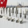 Dental implant materials including titanium screws and ceramic crowns, showcasing various designs and components for dental procedures.