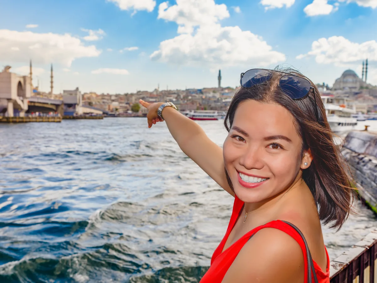 Smiling Dental Pathways patient pointing across the water in Istanbul, Turkey.